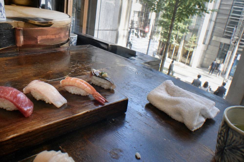 Fresh nigiri sushi arranged on a dark wooden counter